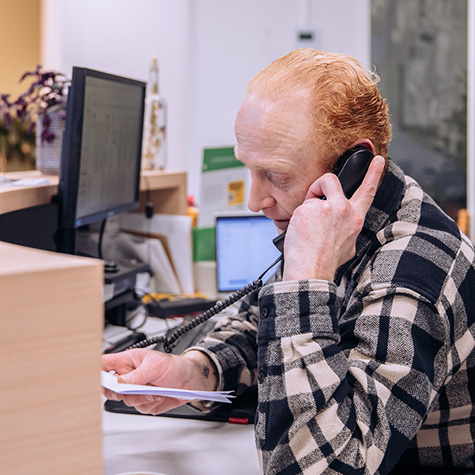 man met geruite bloes telefoneert