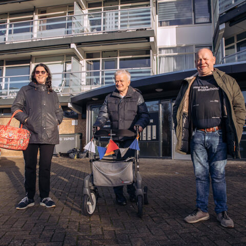 3 mensen staan vooreen flat