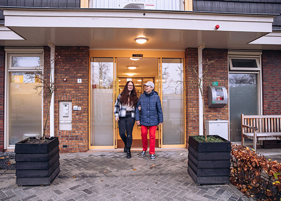 twee mensen komen gearmd de voordeur uit